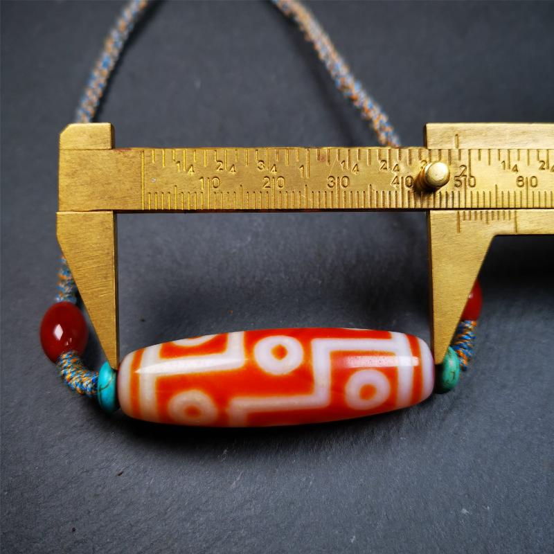 This necklace was hand-woven by Tibetans from Baiyu County, the main bead is a fire agate 9 eyes dzi, paired with 2 turquoise beads and 2 red agate beads,about 30 years old. The length of the necklace can be adjusted, the maximum circumference is about 60cm.