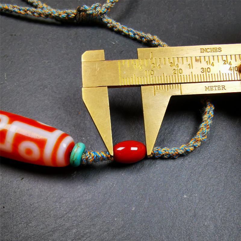This necklace was hand-woven by Tibetans from Baiyu County, the main bead is a fire agate 9 eyes dzi, paired with 2 turquoise beads and 2 red agate beads,about 30 years old. The length of the necklace can be adjusted, the maximum circumference is about 60cm.
