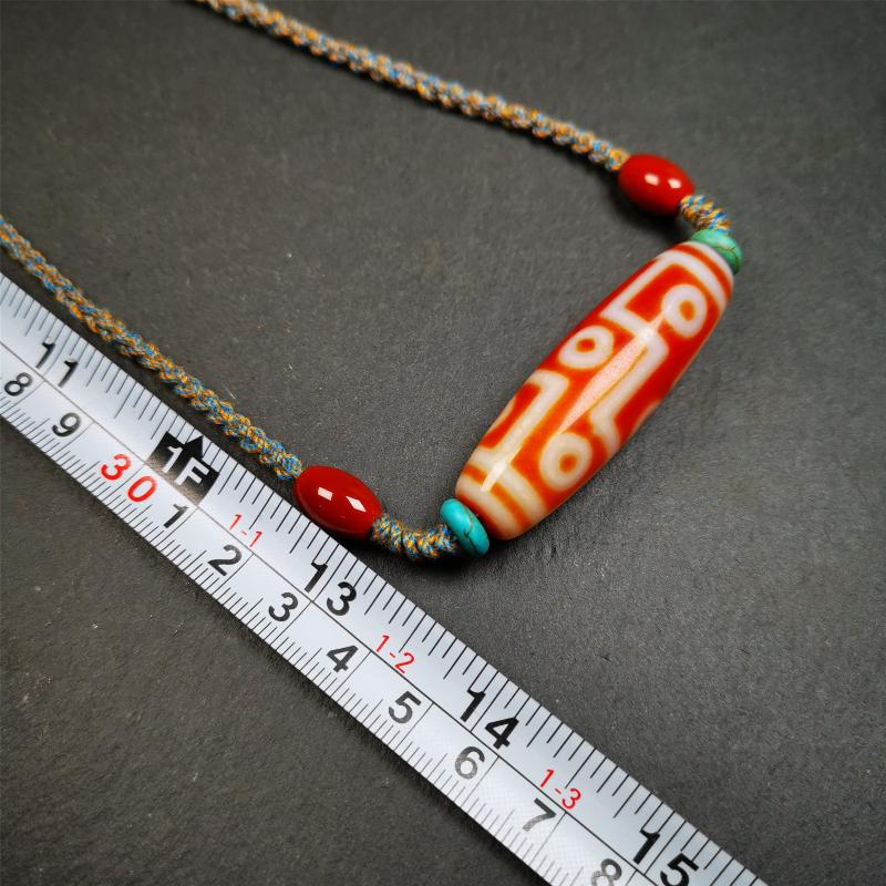 This necklace was hand-woven by Tibetans from Baiyu County, the main bead is a fire agate 9 eyes dzi, paired with 2 turquoise beads and 2 red agate beads,about 30 years old. The length of the necklace can be adjusted, the maximum circumference is about 60cm.