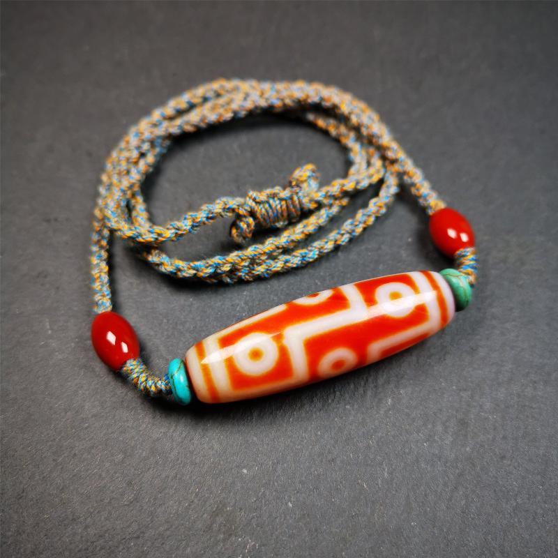 This necklace was hand-woven by Tibetans from Baiyu County, the main bead is a fire agate 9 eyes dzi, paired with 2 turquoise beads and 2 red agate beads,about 30 years old. The length of the necklace can be adjusted, the maximum circumference is about 60cm.