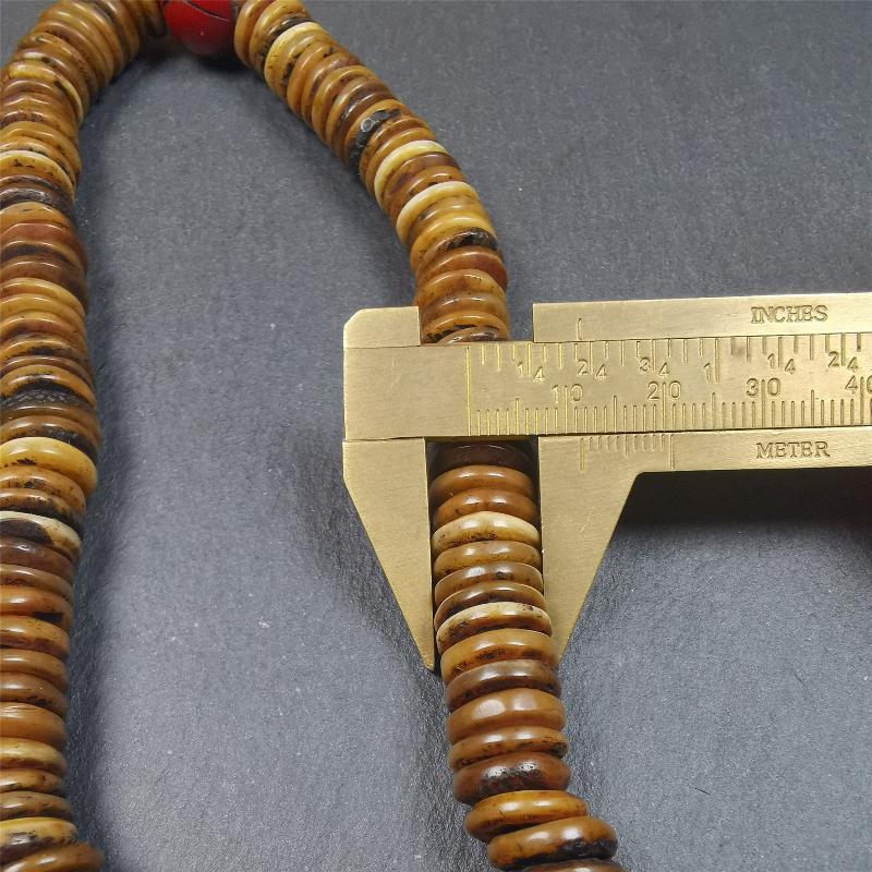This bone carved mala beads is made by Tibetan craftsmen,about 30 years Old. It has 108 flat shape beads,1 red plastic spacer bead,and 1 yak bone guru bead,all hand carved,diameter is 12mm and perimeter is 15".