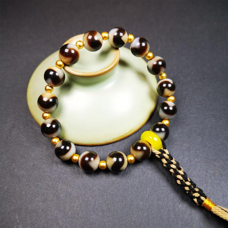 This tiger tooth dzi bracelet was hand-woven by Tibetans from Baiyu County,Tibet. It consists of 15 tiger tooth dzi beads and 15 spacer beads,tie with elastic cord to fit your wrist. Dzi beads are precious jewelry from Tibetan culture which are believed to possess the power of bringing good fortune to the owners. You'll get 1 dzi bracelet as pictures shown.