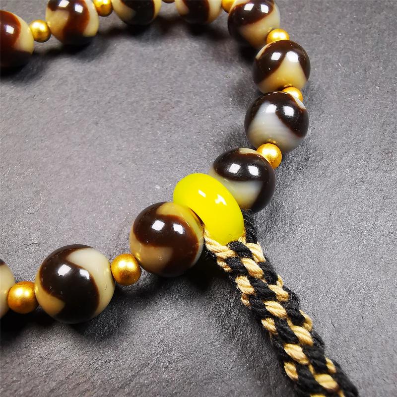 This tiger tooth dzi bracelet was hand-woven by Tibetans from Baiyu County,Tibet. It consists of 15 tiger tooth dzi beads and 15 spacer beads,tie with elastic cord to fit your wrist. Dzi beads are precious jewelry from Tibetan culture which are believed to possess the power of bringing good fortune to the owners. You'll get 1 dzi bracelet as pictures shown.