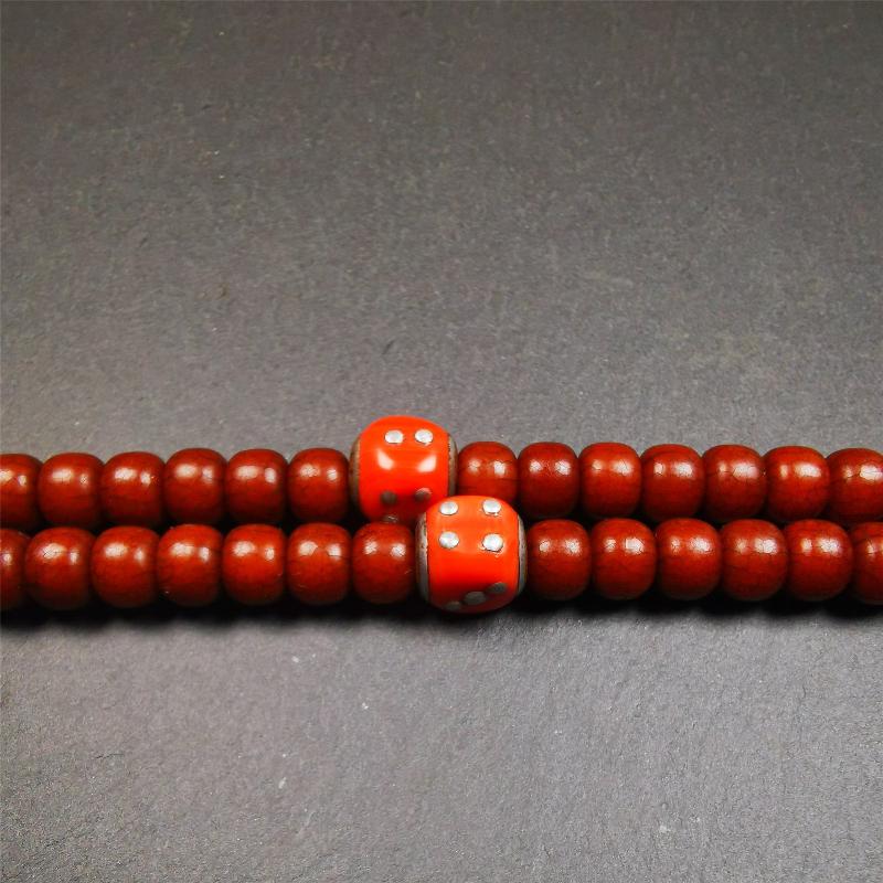 These marker beads were handmade by Tibetan craftsmen and come from Hepo Town, Baiyu County, the birthplace of the famous Tibetan handicrafts. It is made of plastic,inlaid cold iron,orange color,size is 0.47" × 0.47". Fit for 8-12mm mala (The reference in the photo is 8mm mala)