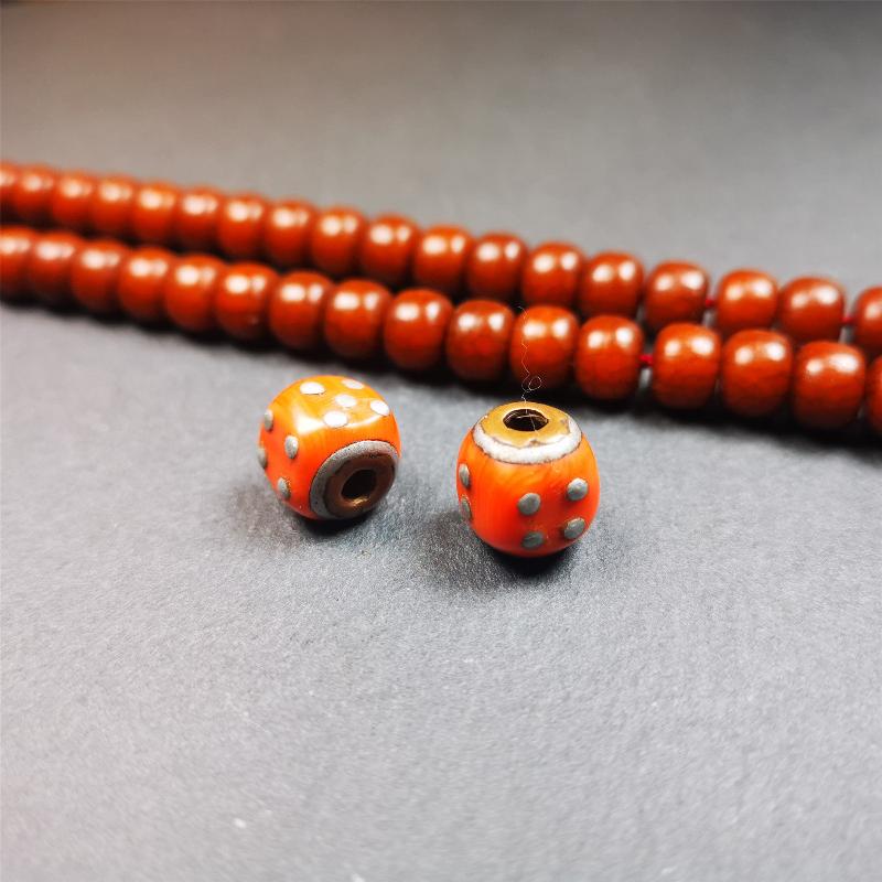These marker beads were handmade by Tibetan craftsmen and come from Hepo Town, Baiyu County, the birthplace of the famous Tibetan handicrafts. It is made of plastic,inlaid cold iron,orange color,size is 0.47" × 0.47". Fit for 8-12mm mala (The reference in the photo is 8mm mala)