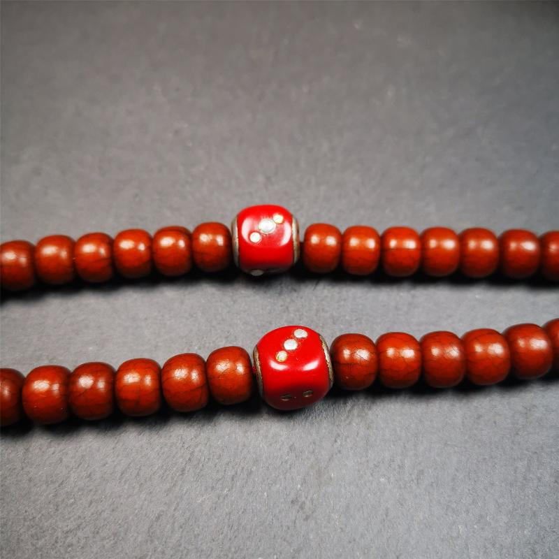 These marker beads were handmade by Tibetan craftsmen and come from Hepo Town, Baiyu County, the birthplace of the famous Tibetan handicrafts. It is made of plastic,inlaid cold iron,red color,size is 0.47" × 0.47". Fit for 8-12mm mala (The reference in the photo is 8mm mala)