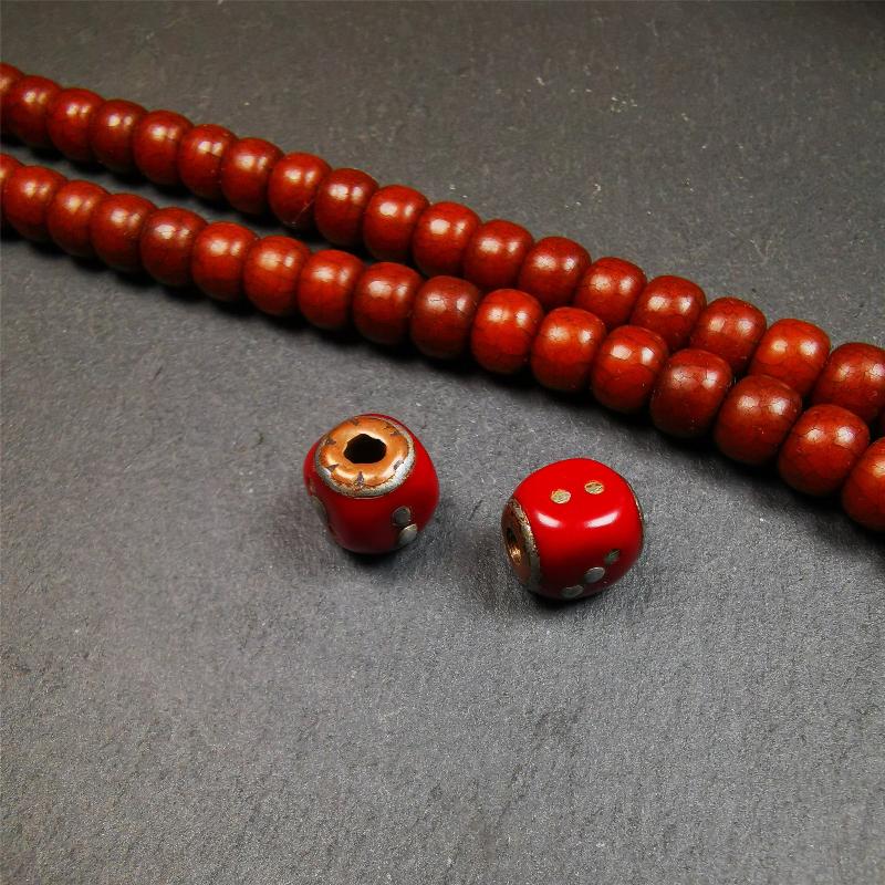 These marker beads were handmade by Tibetan craftsmen and come from Hepo Town, Baiyu County, the birthplace of the famous Tibetan handicrafts. It is made of plastic,inlaid cold iron,red color,size is 0.47" × 0.47". Fit for 8-12mm mala (The reference in the photo is 8mm mala)