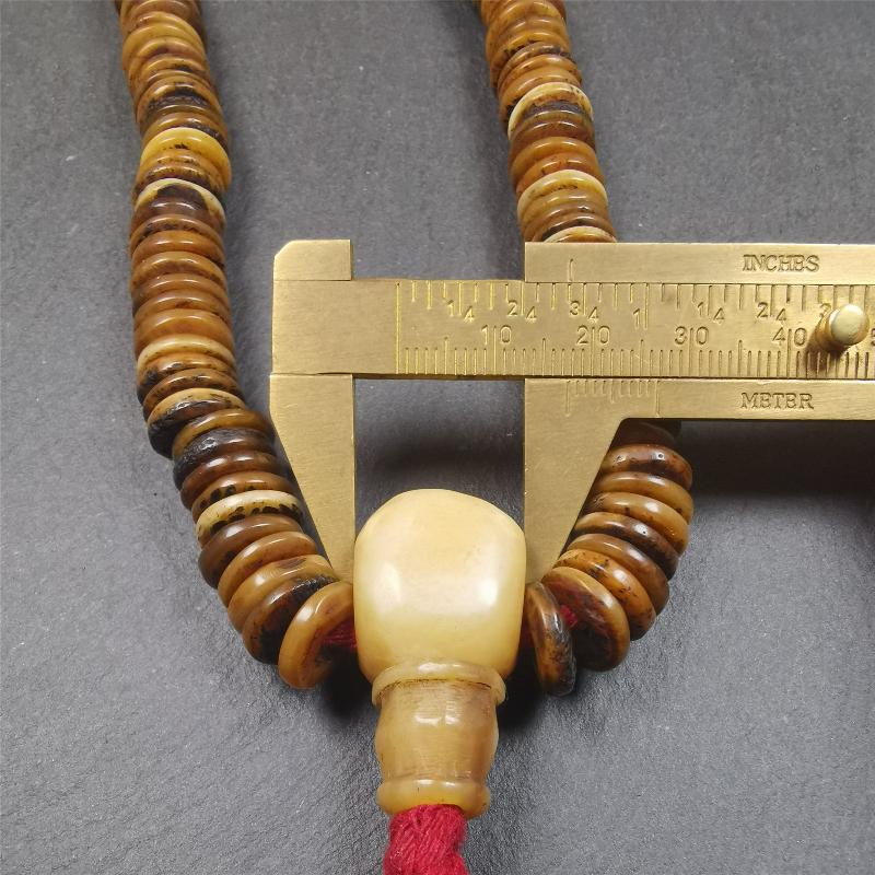 This bone carved mala beads is made by Tibetan craftsmen,about 30 years Old. It has 108 flat shape beads,1 red plastic spacer bead,and 1 yak bone guru bead,all hand carved,diameter is 12mm and perimeter is 15".