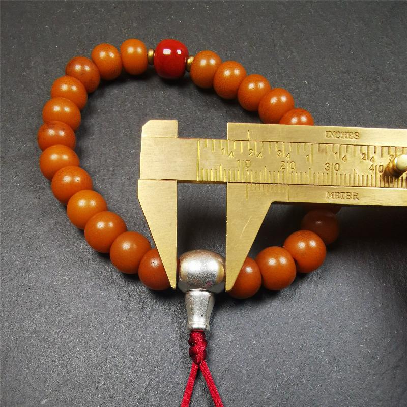 This mala was made by Tibetan craftsmen. It is made of Corypha Linn Seeds, diameter of 10mm / 0.4",circumference is 22cm / 8.7" ,with agate spacer bead, end of a white copper guru bead.