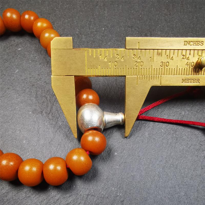 This mala was made by Tibetan craftsmen. It is made of Corypha Linn Seeds, diameter of 10mm / 0.4",circumference is 22cm / 8.7" ,with agate spacer bead, end of a white copper guru bead.