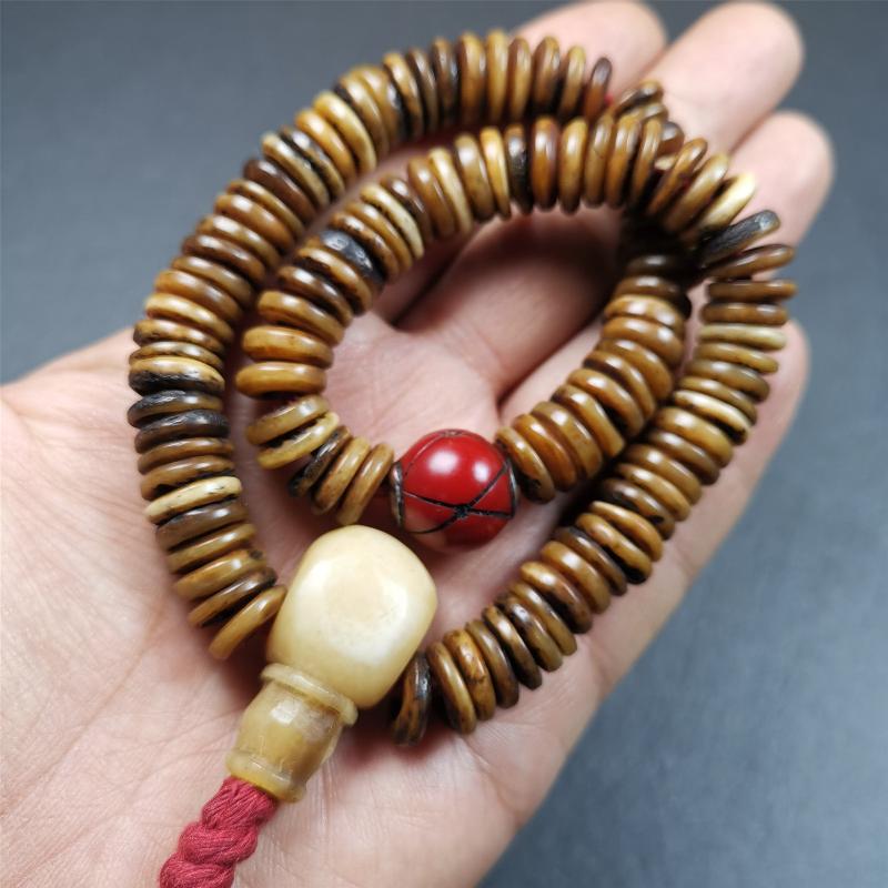 This bone carved mala beads is made by Tibetan craftsmen,about 30 years Old. It has 108 flat shape beads,1 red plastic spacer bead,and 1 yak bone guru bead,all hand carved,diameter is 12mm and perimeter is 15".