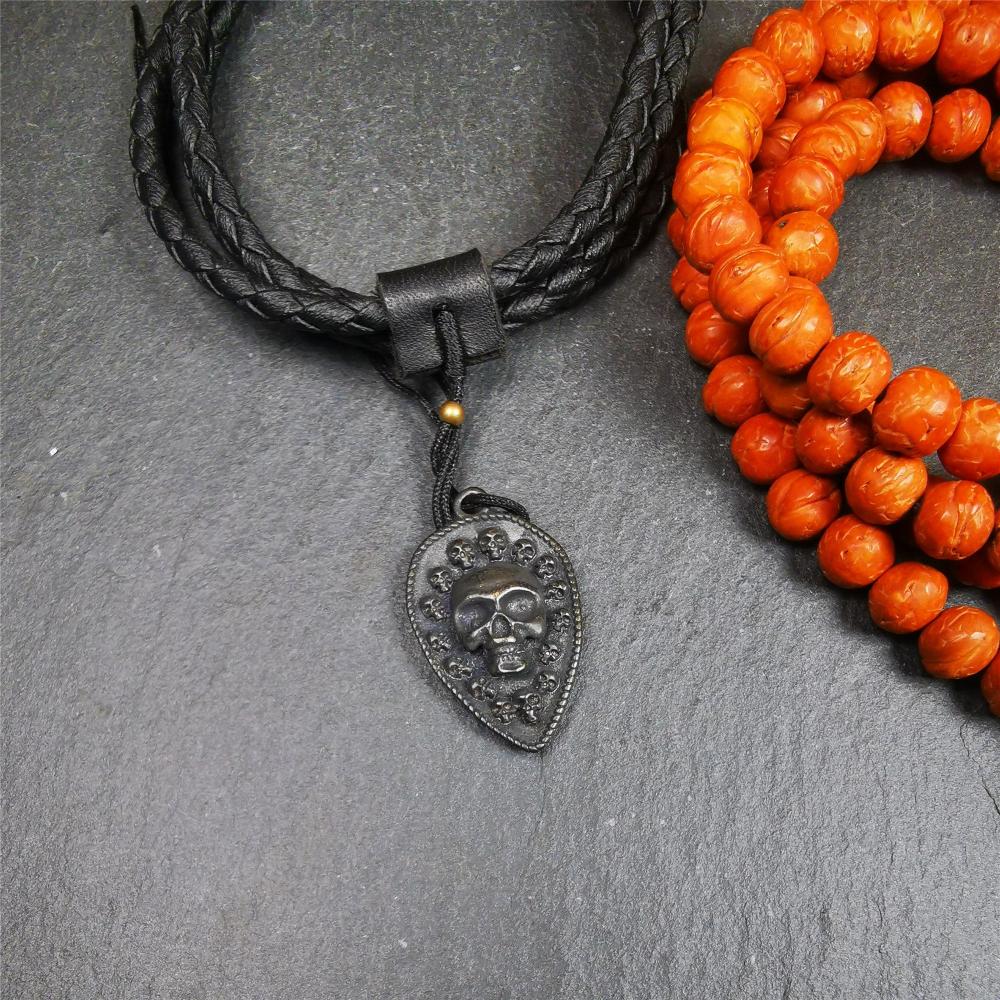 This skull vajra pendant was handmade by Tibetan craftsmen,it is made of thokcha, whole body is blcak,the front is skull and the back is vajra,size is 30mm × 18mm,comes with a black leather cord.