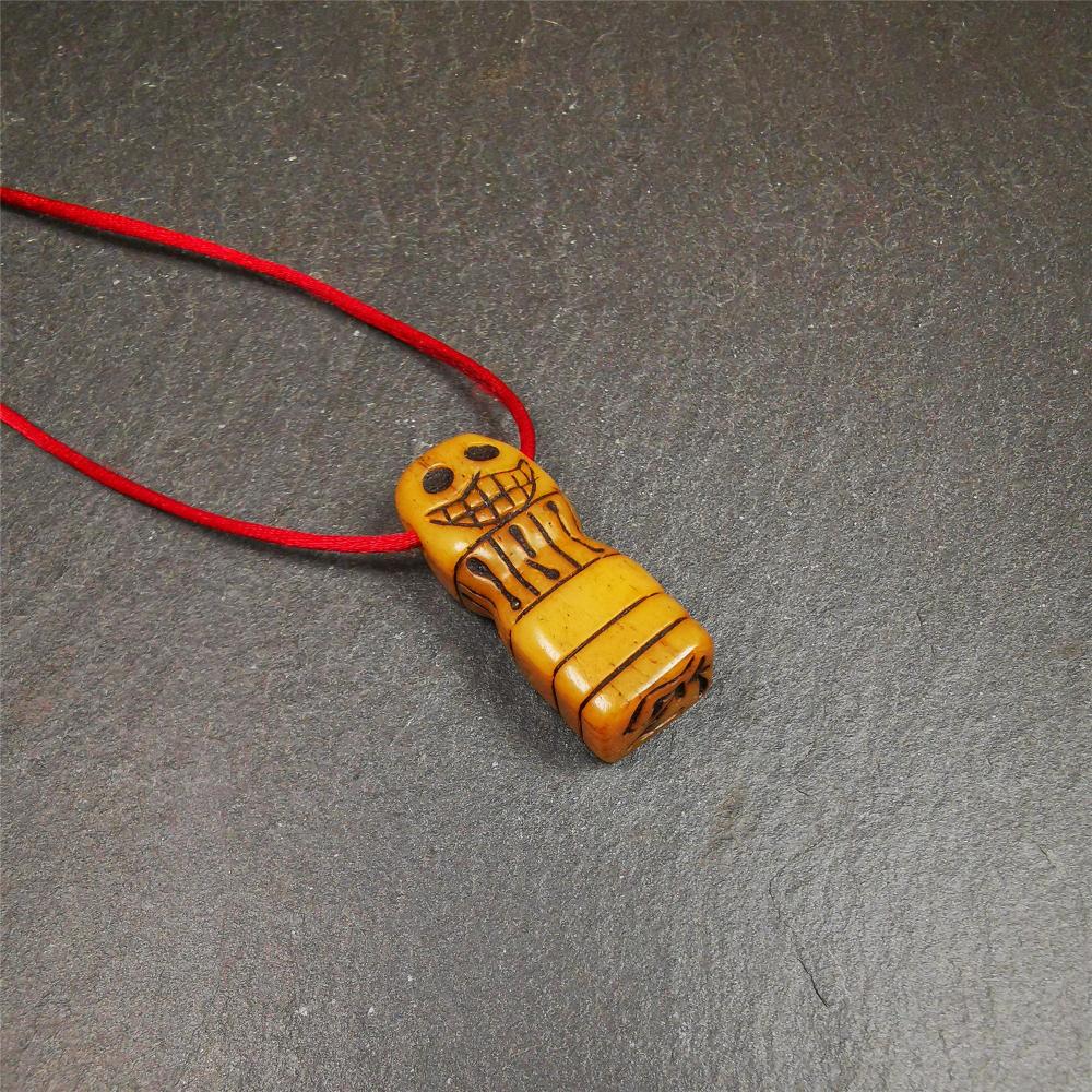 This skull seal amulet was made by Tibetan craftsmen and come from Hepo Town, Baiyu County, the birthplace of the famous Tibetan handicrafts. It's made of yak bone,yellow color,carved skull shape,and OM letter at the bottom,height is inches. You can make it a pendant, keychain.