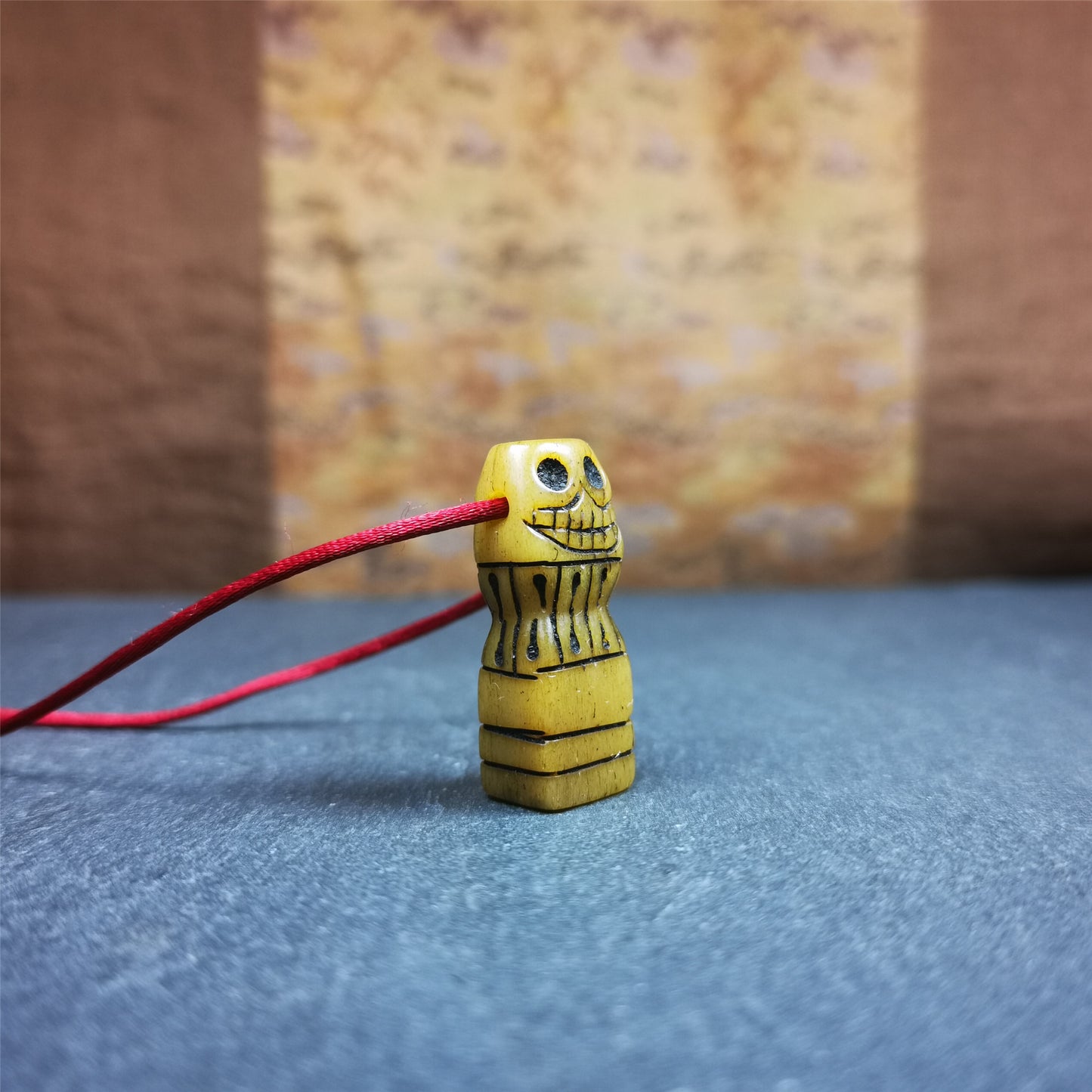 This skull seal amulet was made by Tibetan craftsmen and come from Hepo Town, Baiyu County, the birthplace of the famous Tibetan handicrafts. It's made of yak bone,yellow color,carved skull shape,and OM letter at the bottom,height is inches. You can make it a pendant, keychain.