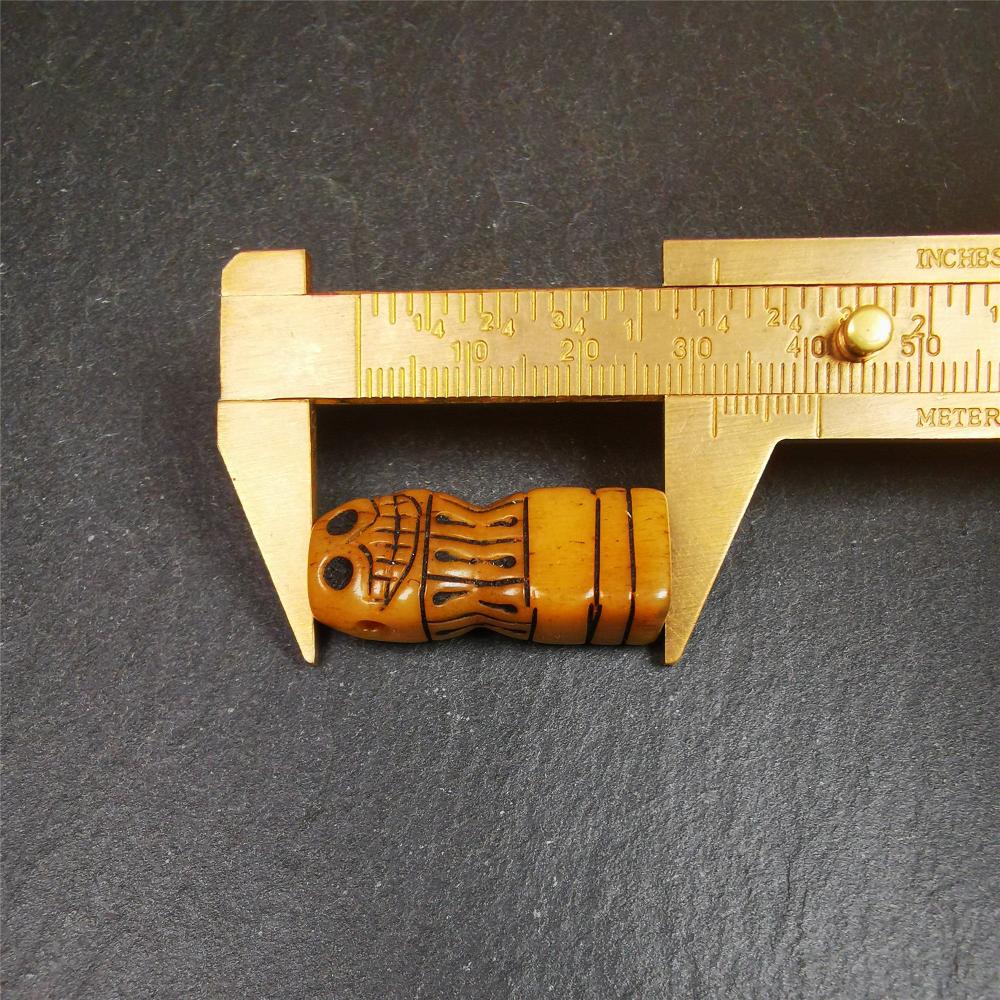This skull seal amulet was made by Tibetan craftsmen and come from Hepo Town, Baiyu County, the birthplace of the famous Tibetan handicrafts. It's made of yak bone,yellow color,carved skull shape,and OM letter at the bottom,height is inches. You can make it a pendant, keychain.