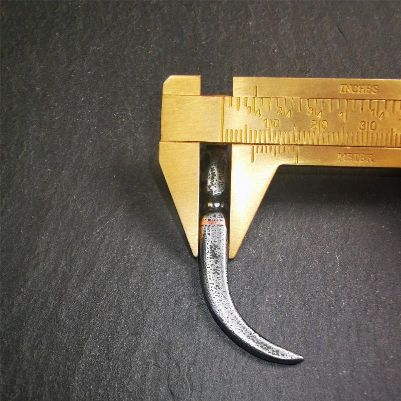 This wolf tooth pendant is made by Tibetan craftsmen and come from Hepo Town, Baiyu County, the birthplace of the famous Tibetan handicrafts. It's made of cold iron and inlaid copper,the body is black color,length is 2.16 inches. You can make it a necklace or mala pendant, or keychain.