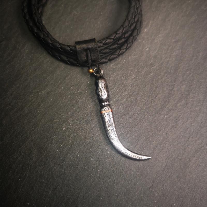 This wolf tooth pendant is made by Tibetan craftsmen and come from Hepo Town, Baiyu County, the birthplace of the famous Tibetan handicrafts. It's made of cold iron and inlaid copper,the body is black color,length is 2.16 inches. You can make it a necklace or mala pendant, or keychain.