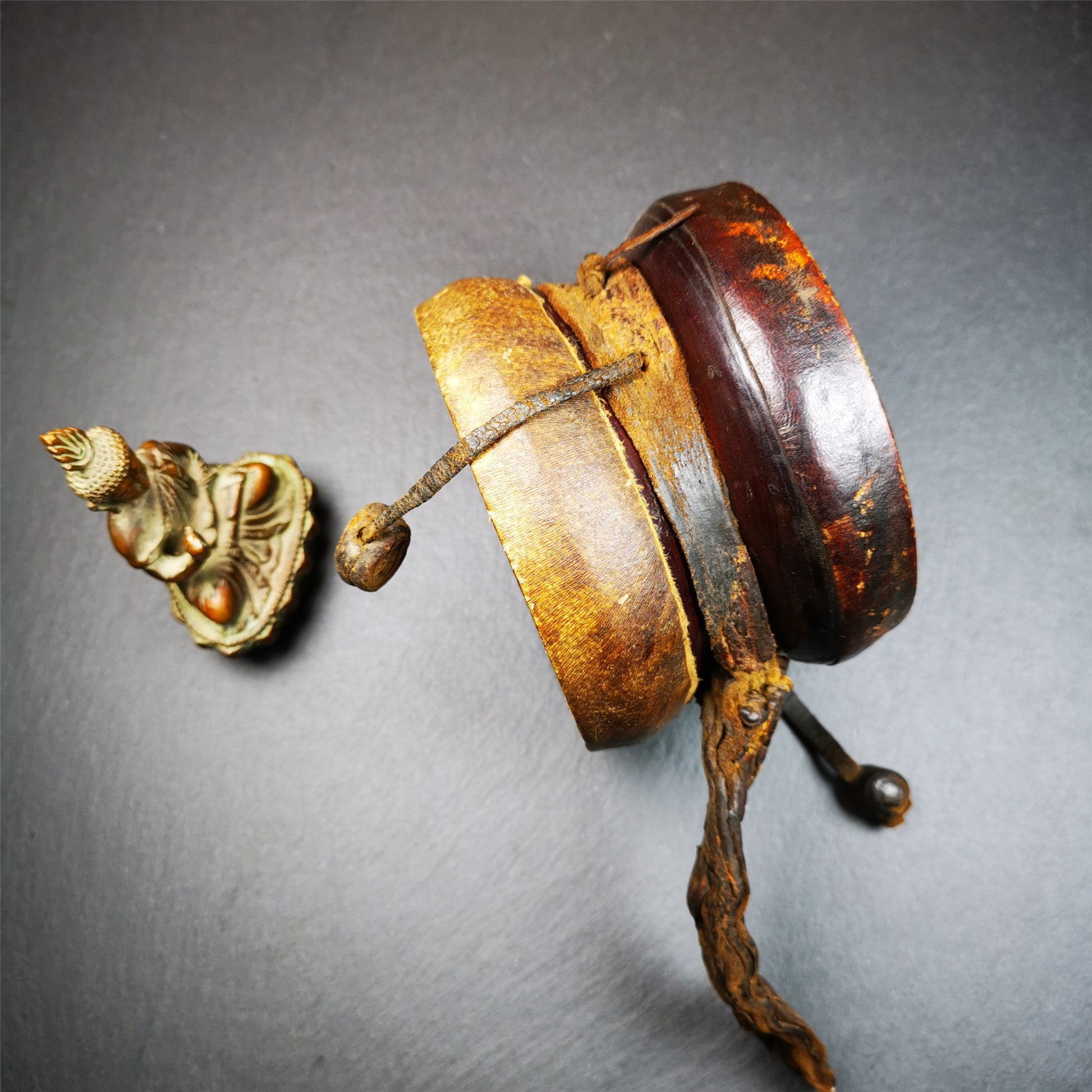 This Old Damaru Chod Drum was collected from a vallage in Gerze Tibet,about 60 years old,used and blessed by lama. It is made of Wood,Sheepskin and leather cord,the drumsticks are also made of leather cords, the drum skin shows different colors because one side of it was damaged and repaired long time ago.