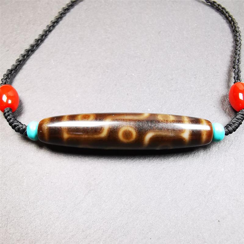 This necklace was hand-woven by Tibetans from Baiyu County, the main bead is a brown color 9 eyes dzi, paired with 2 turquoise beads and 2 red agate beads,about 30 years old. The length of the necklace can be adjusted, the maximum circumference is about 60cm.