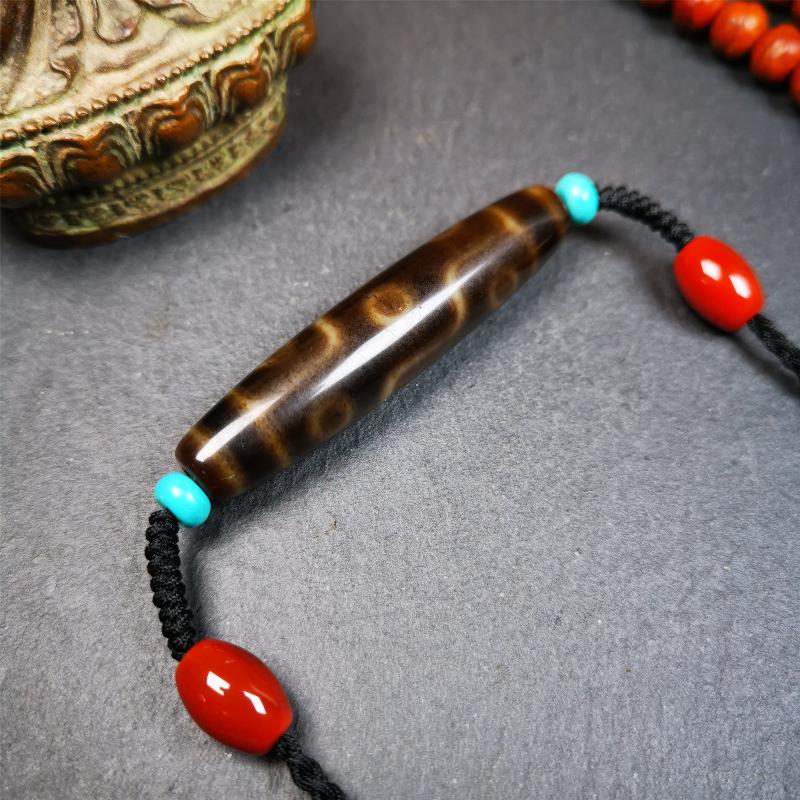 This necklace was hand-woven by Tibetans from Baiyu County, the main bead is a brown color 9 eyes dzi, paired with 2 turquoise beads and 2 red agate beads,about 30 years old. The length of the necklace can be adjusted, the maximum circumference is about 60cm.