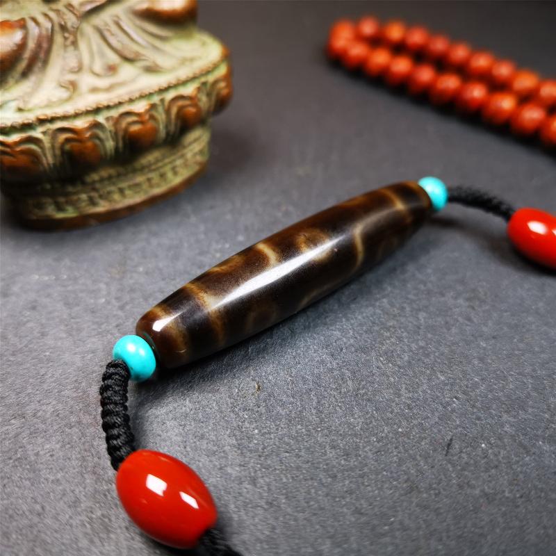 This necklace was hand-woven by Tibetans from Baiyu County, the main bead is a brown color 9 eyes dzi, paired with 2 turquoise beads and 2 red agate beads,about 30 years old. The length of the necklace can be adjusted, the maximum circumference is about 60cm.