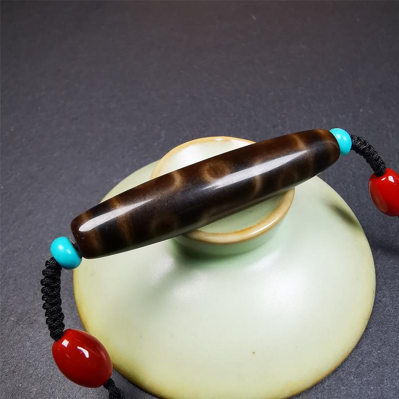 This necklace was hand-woven by Tibetans from Baiyu County, the main bead is a brown color 9 eyes dzi, paired with 2 turquoise beads and 2 red agate beads,about 30 years old. The length of the necklace can be adjusted, the maximum circumference is about 60cm.