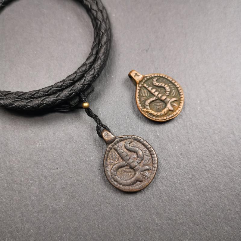 These amulet were handmade by Tibetan craftsmen from Tibet in 1990's. It's made of copper/brass,brown/yellow color,diameter is 0.83 inch,comes with a leather cord. You can make it into a necklace,or bag hanging