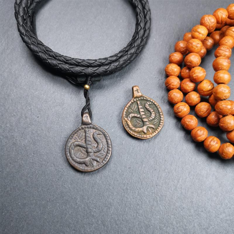These amulet were handmade by Tibetan craftsmen from Tibet in 1990's. It's made of copper/brass,brown/yellow color,diameter is 0.83 inch,comes with a leather cord. You can make it into a necklace,or bag hanging