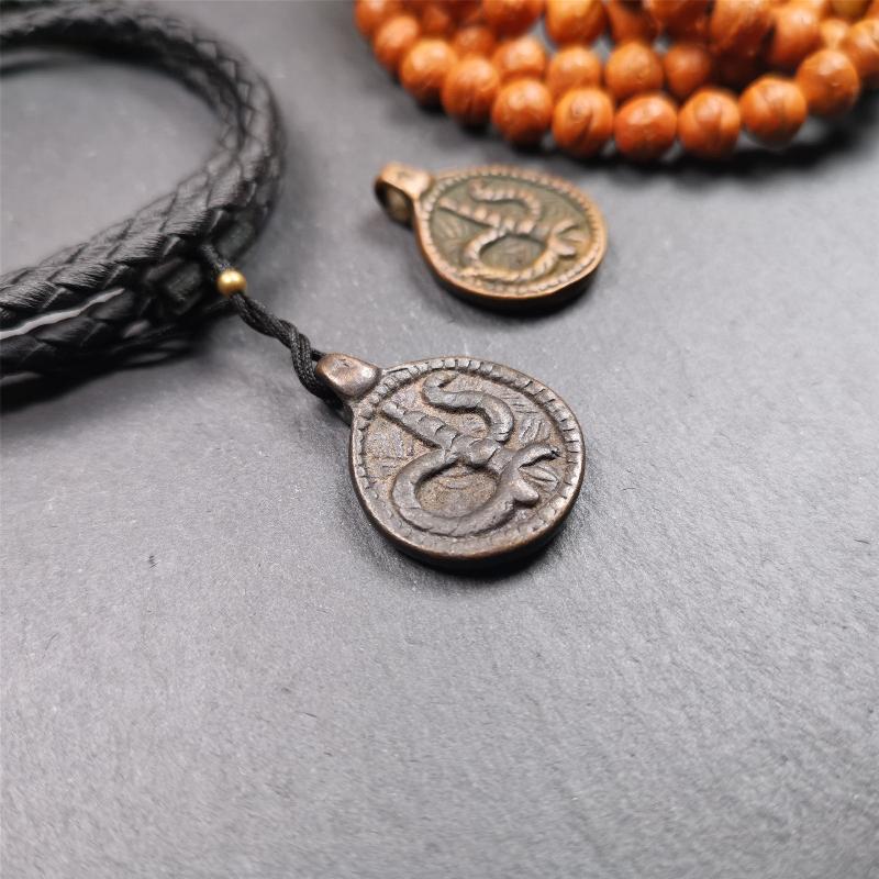 These amulet were handmade by Tibetan craftsmen from Tibet in 1990's. It's made of copper/brass,brown/yellow color,diameter is 0.83 inch,comes with a leather cord. You can make it into a necklace,or bag hanging