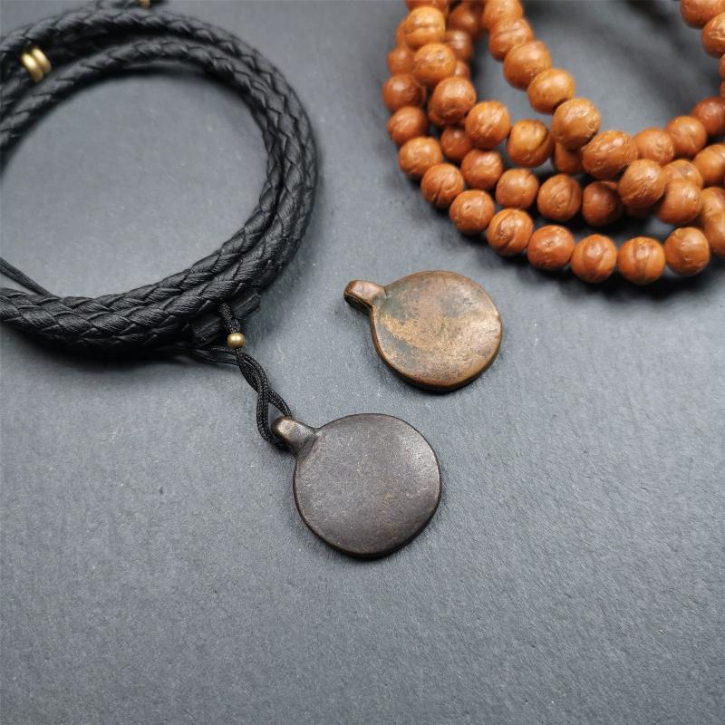 These amulet were handmade by Tibetan craftsmen from Tibet in 1990's. It's made of copper/brass,brown/yellow color,diameter is 0.83 inch,comes with a leather cord. You can make it into a necklace,or bag hanging