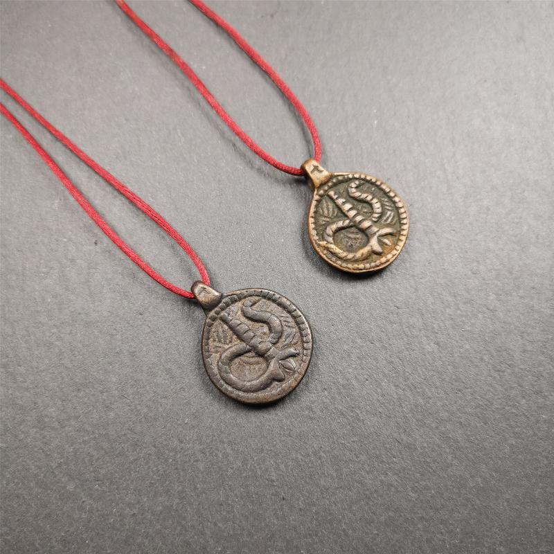 These amulet were handmade by Tibetan craftsmen from Tibet in 1990's. It's made of copper/brass,brown/yellow color,diameter is 0.83 inch,comes with a leather cord. You can make it into a necklace,or bag hanging