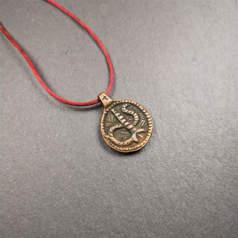 These amulet were handmade by Tibetan craftsmen from Tibet in 1990's. It's made of copper/brass,brown/yellow color,diameter is 0.83 inch,comes with a leather cord. You can make it into a necklace,or bag hanging