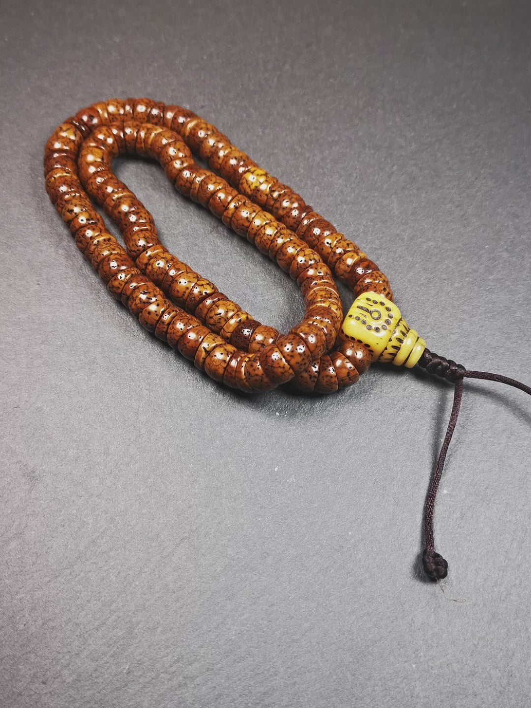 This lotus seed mala was collected from Baiyu county,about 40 years old,hold and blessed by a lama. It is composed of 108 bodhi seed beads, bevel cut shape,brown color,and 1 yak bone guru bead.