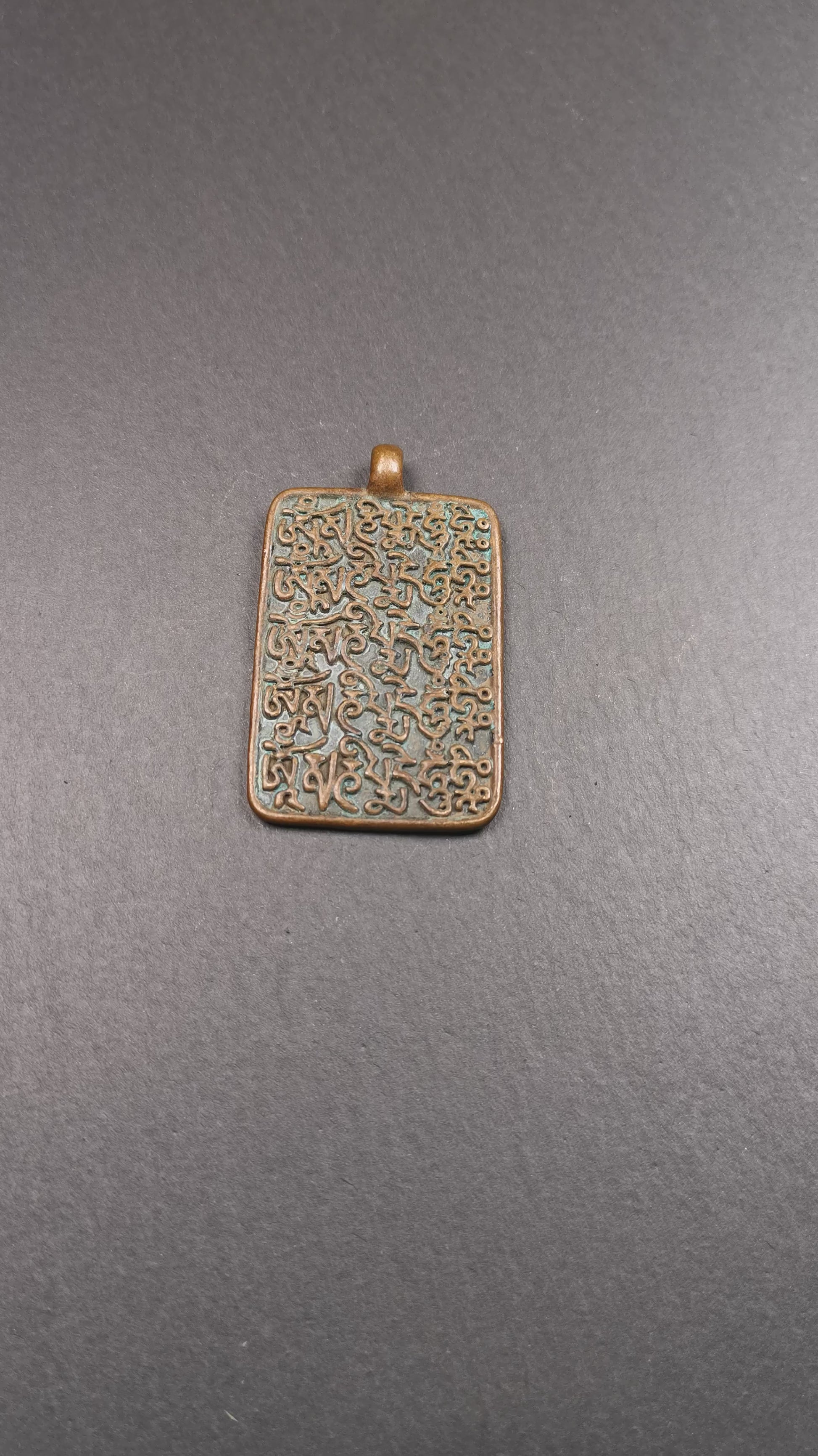 This badge is made by Tibetan craftsmen from Hepo Town, Baiyu County, the birthplace of the famous Tibetan handicrafts. It is made of copper, 2.44 × 1.42 inches. The front is the OM mantra and the back is body, speech, and mind.