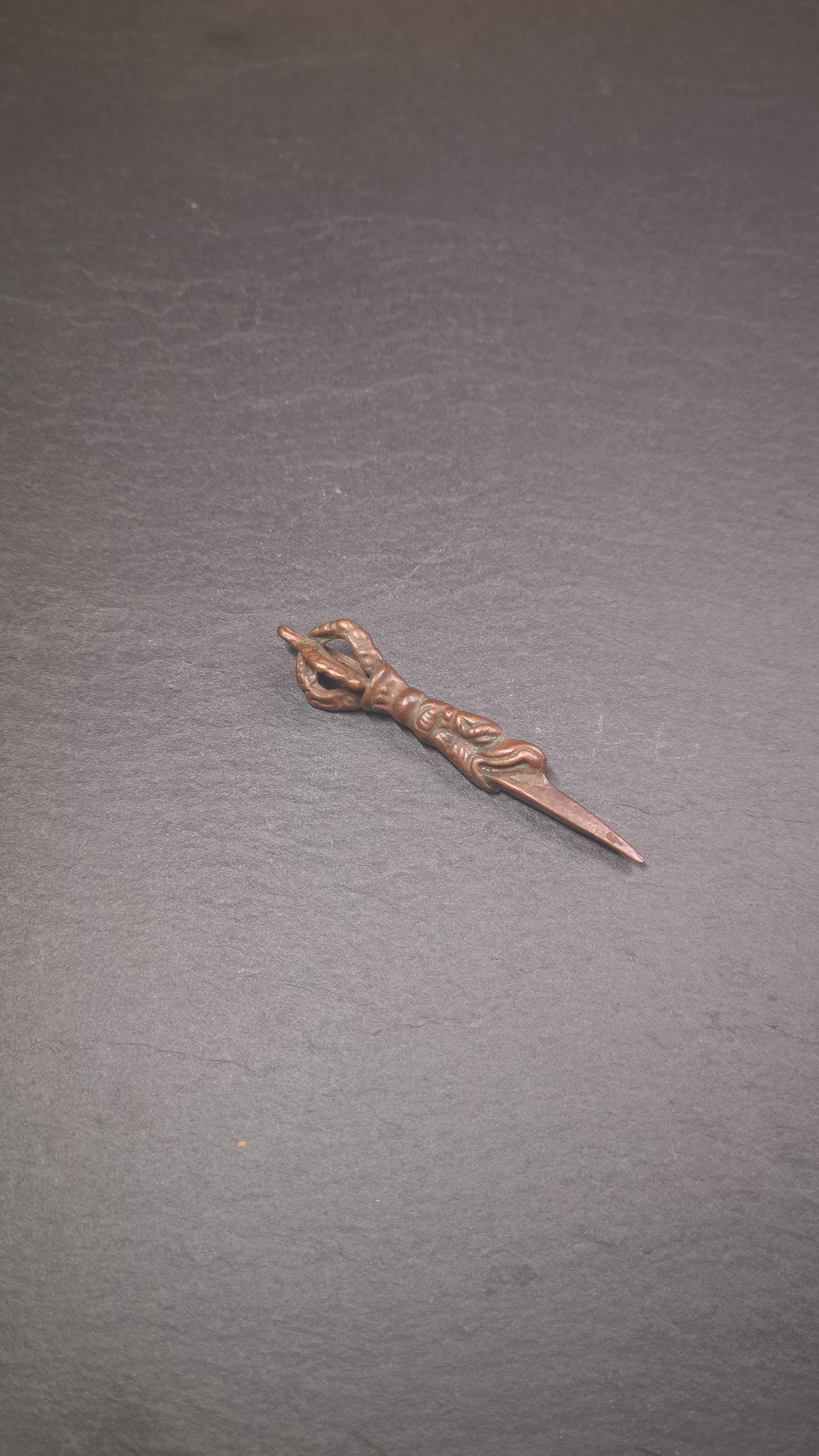 This vintage Phurba pendant was collected from gengqing Monastery(Derge,Tibet),handmade of copper. It is total 2.6 inches,brown color,on top of it is a dragon, the tail of the dragon is half vajra, from the dragon's mouth comes a phurba.