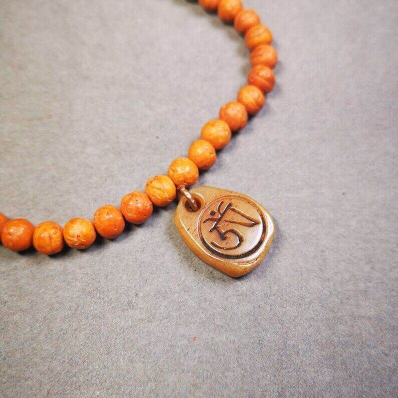 Yak Bone Carved Amulet,Om Pendant for Mala,Bag Hanging - Tibetan Buddhist mala beads, close-up detail
