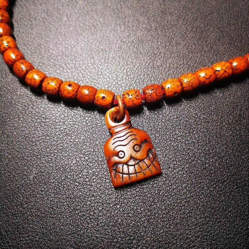 Yak Bone Carved Skull Prayer Bead Pendant - Tibetan Buddhist art, close-up detail
