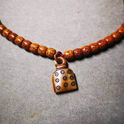 Yak Bone Carved Mantra Dot Prayer Bead Pendant - Tibetan Buddhist art, close-up detail