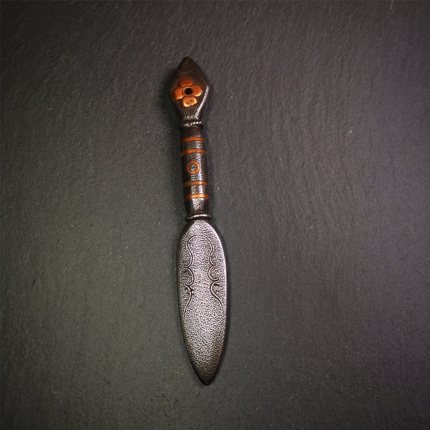 This kila / phurba was handmade by Tibetan craftsmen from Tibet in 2000s.  It's a kila dagger,made of cold iron, carved cloud pattern, inlaid red copper, made into a dzi pattern on handle, and the petals of the tail hanging ring
