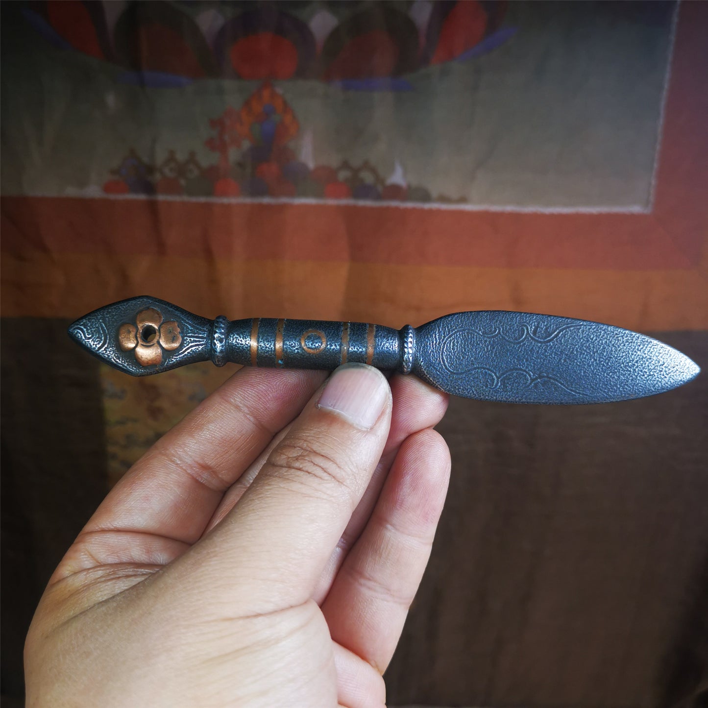 This kila / phurba was handmade by Tibetan craftsmen from Tibet in 2000s.  It's a kila dagger,made of cold iron, carved cloud pattern, inlaid red copper, made into a dzi pattern on handle, and the petals of the tail hanging ring