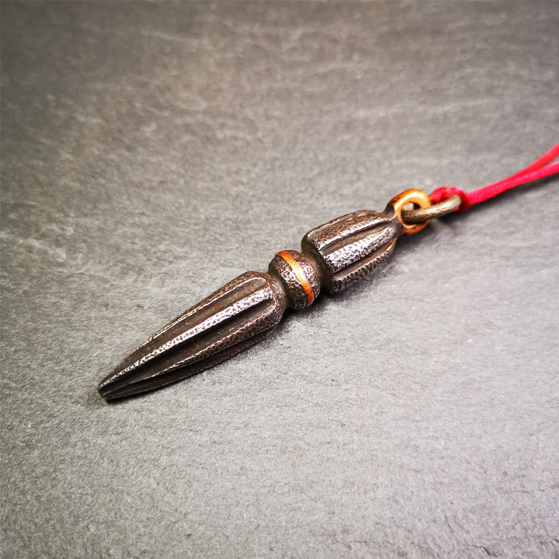 This handmade Dorje Phurba was crafted by Tibetan craftsmen from Hepo Town, Baiyu County, Tibet. The length is 2.5 inches,black color,the upper part is a vajra, and the lower part is a phurba. A copper wire is inlaid on the waist of the phurba.