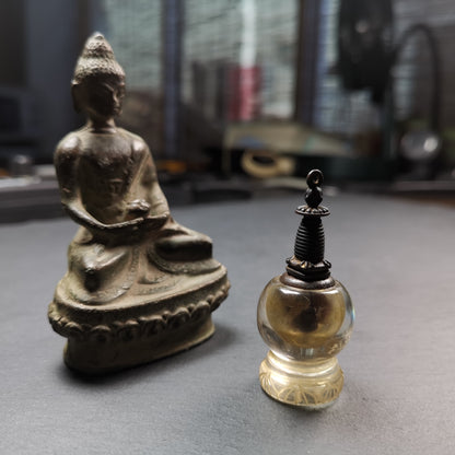 This crystal stupa was hand carved by Tibetan craftsmen from Tibet in 1990s,fulfilled consecrations and blessed in Kathok monastery.
Its lid is metal and body is crystal, the lid can be opened and you can place offerings inside,like mani rilbu or zung consecration.

You can make it into a necklace, or put it in your shrine / altar.