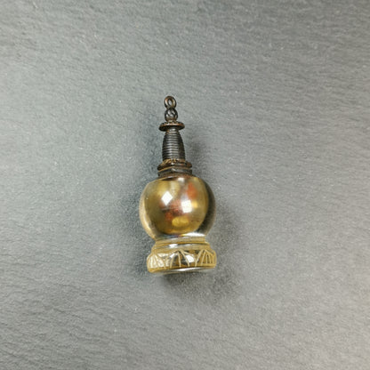 This crystal stupa was hand carved by Tibetan craftsmen from Tibet in 1990s,fulfilled consecrations and blessed in Kathok monastery.
Its lid is metal and body is crystal, the lid can be opened and you can place offerings inside,like mani rilbu or zung consecration.

You can make it into a necklace, or put it in your shrine / altar.