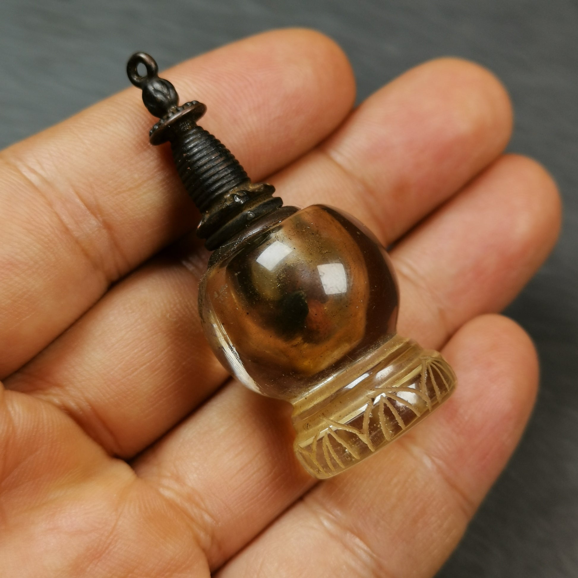 This crystal stupa was hand carved by Tibetan craftsmen from Tibet in 1990s,fulfilled consecrations and blessed in Kathok monastery.
Its lid is metal and body is crystal, the lid can be opened and you can place offerings inside,like mani rilbu or zung consecration.

You can make it into a necklace, or put it in your shrine / altar.