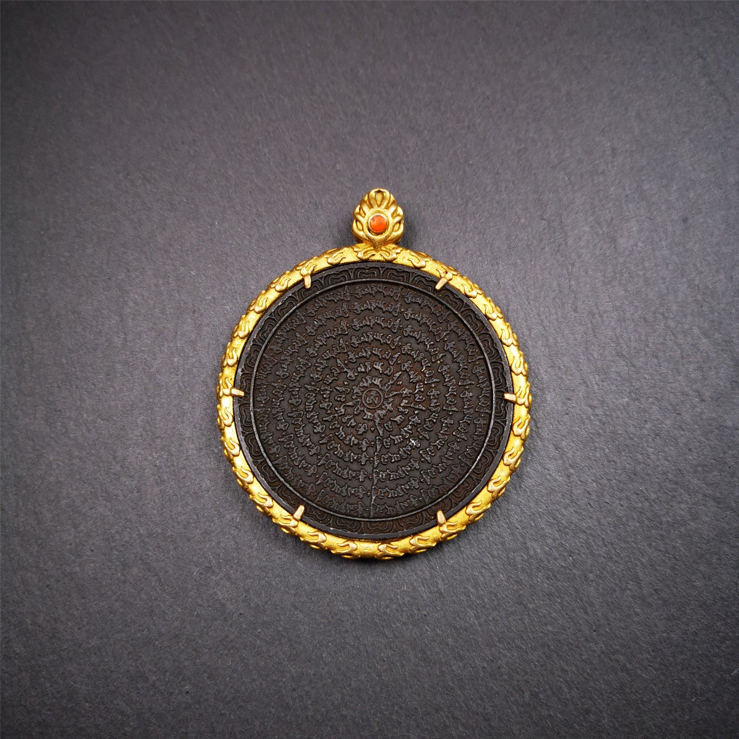 This badge is made by Tibetan craftsmen and come from Hepo Town, Baiyu County,Tibet. It is made of thokcha, edging with copper,round shape, 2.52 inche diameter. The OM MANI PADME HUM mantra arranged in concentric circles.