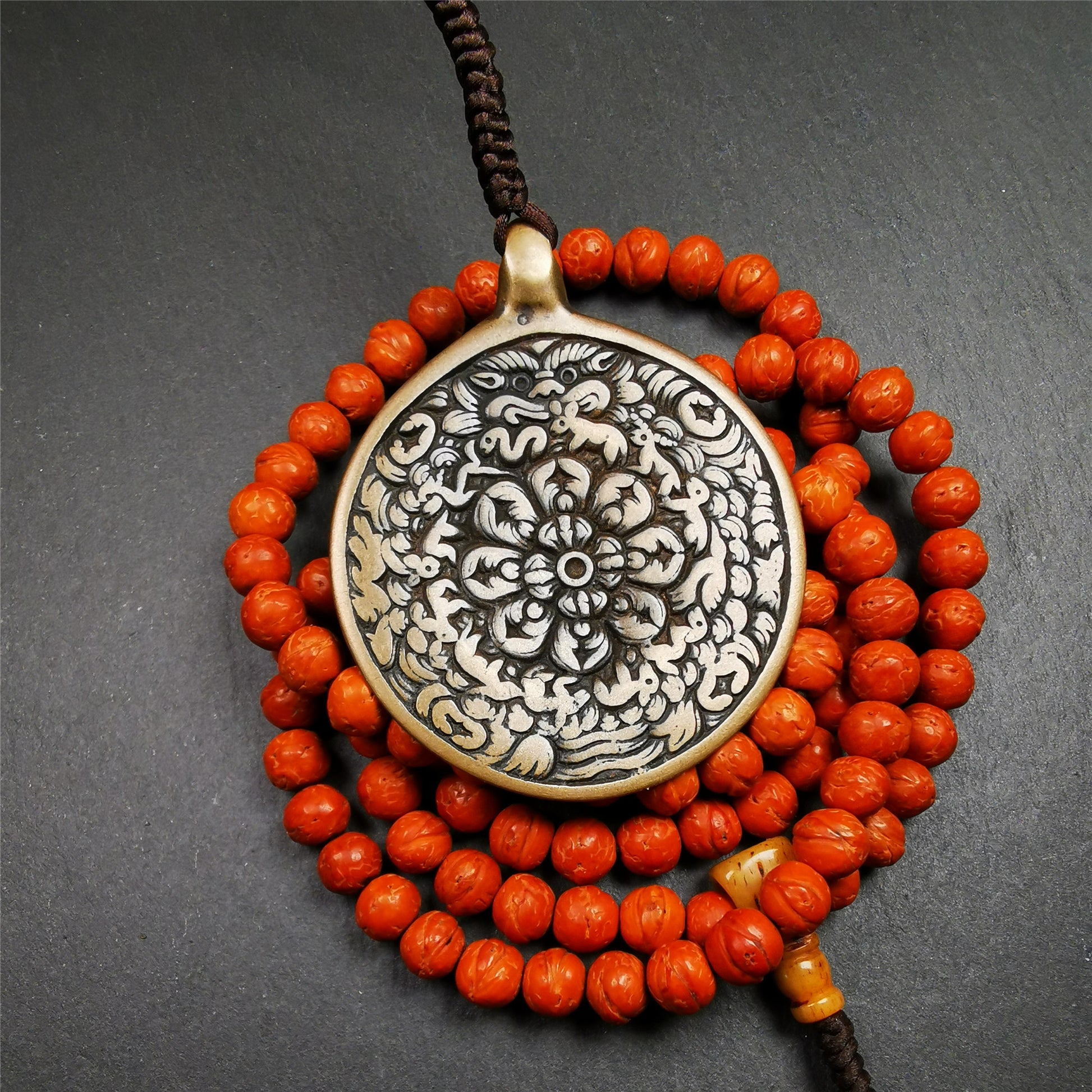 This unique meling amulet is handmade in Baiyu County Tibet,Where is the famous handicraft industry base in Tibetan areas.  It is made of lima brass,2.16 inches diameter,the front center is a very rare mandala flower shape.