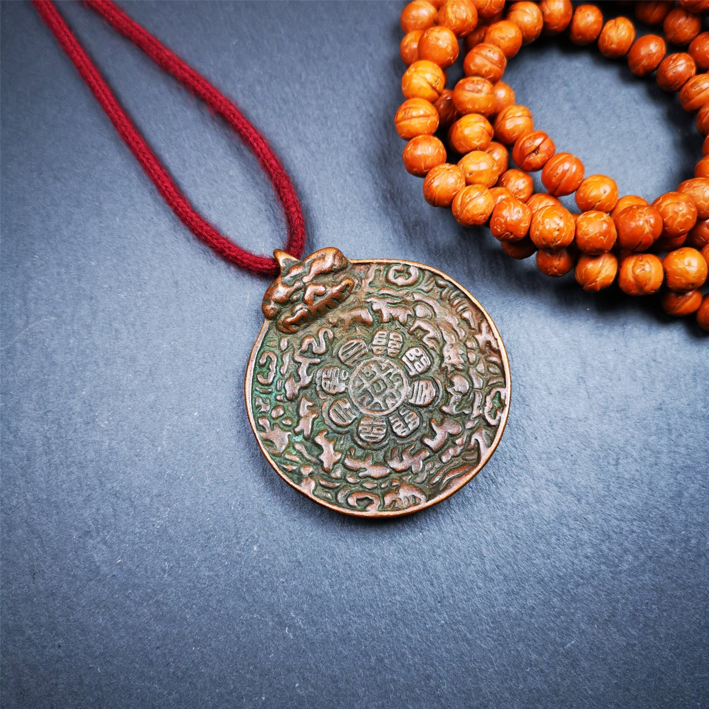 This unique melong badge was collected from Kathok Monastery for 50 years. It is round shape ,made of copper and carved 2 sided pattern. Its hanging ring is Kirtimukha,the fron is Tibetan Budhist calendar symbol - melong,and the back is mani jewel.