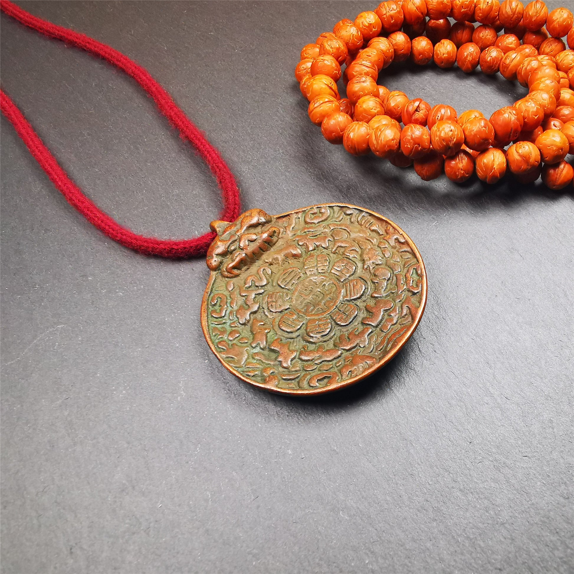 This unique melong badge was collected from Kathok Monastery for 50 years. It is round shape ,made of copper and carved 2 sided pattern. Its hanging ring is Kirtimukha,the fron is Tibetan Budhist calendar symbol - melong,and the back is mani jewel.