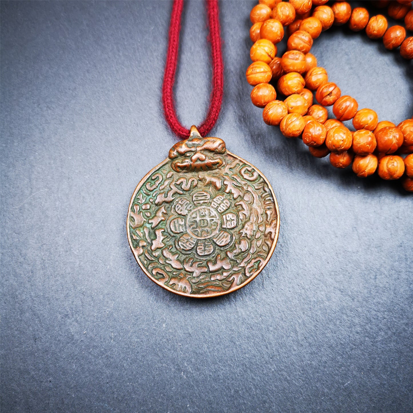 This unique melong badge was collected from Kathok Monastery for 50 years. It is round shape ,made of copper and carved 2 sided pattern. Its hanging ring is Kirtimukha,the fron is Tibetan Budhist calendar symbol - melong,and the back is mani jewel.