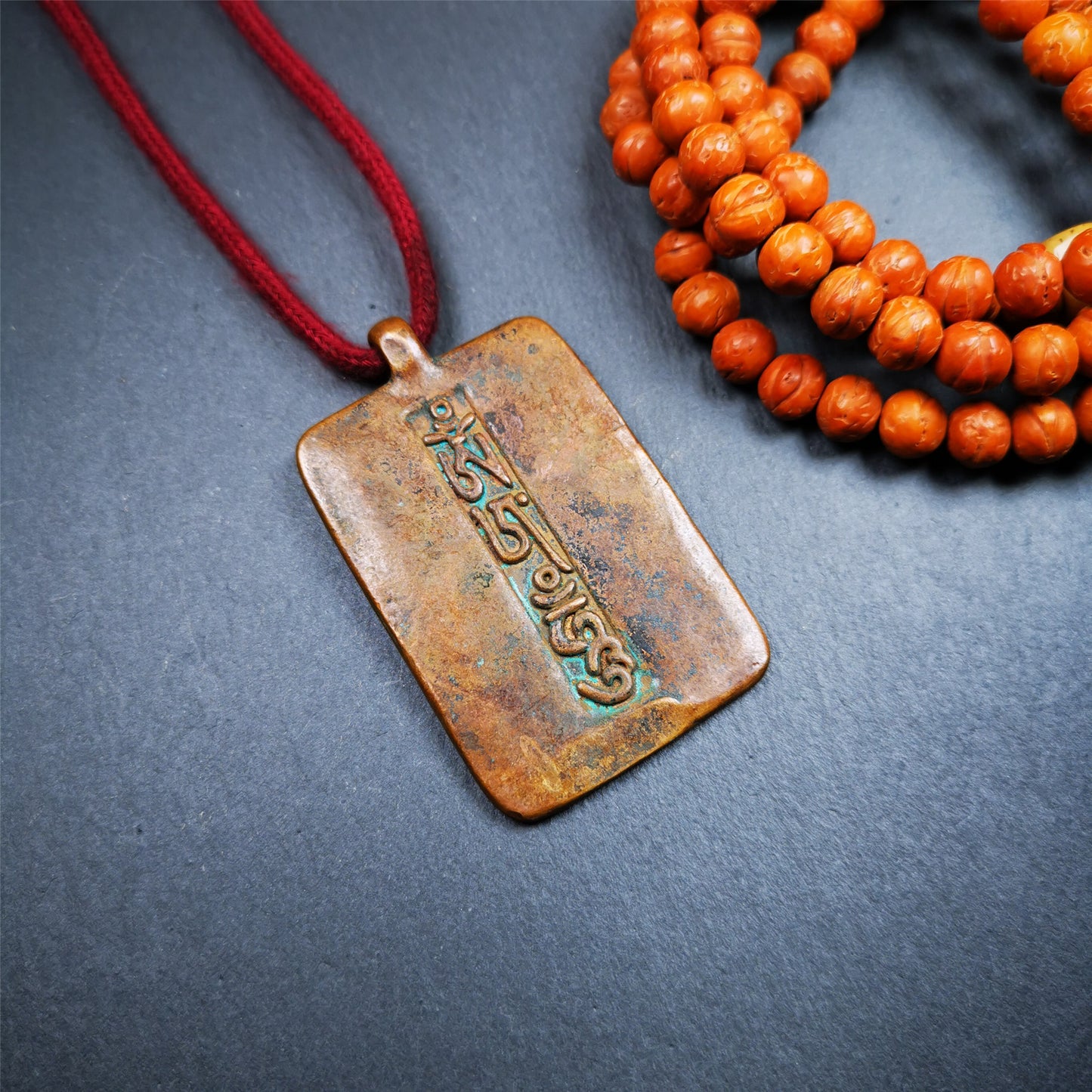This badge is made by Tibetan craftsmen from Hepo Town, Baiyu County, the birthplace of the famous Tibetan handicrafts. It is made of copper, 2.44 × 1.42 inches. The front is the OM mantra and the back is body, speech, and mind.